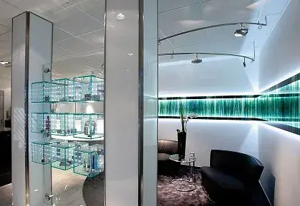 Modernes Wartezimmer beim Optiker mit Glasregalen für Brillen und stilvoller Beleuchtung.